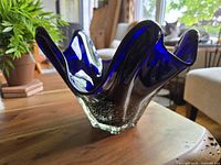 Angled side view showing the cobalt blue ruffled edge and slight translucency with silver flecking in the base