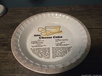 Top view of vintage ceramic Watkins cheesecake pie plate showing central printed recipe and decorative rim.