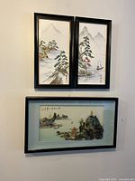 Photo showing two vertical hand painted tile panels above one horizontal framed 3D artwork on wall.