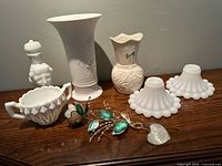 7-piece vintage porcelain and milk glass collectible group including vases, decanter, sugar bowl, candle holders, and decorative flower.