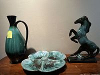 Photo of all three items together on a wooden surface: horse figurine, vase, and Dogwood leaf dish.