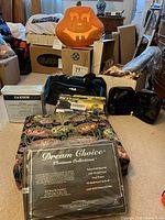 Image showing Cannon and Dream Choice sheet sets in packaging, lighted pumpkin decoration, FILA travel bag, several boxes, and the animal print makeup case.