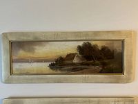 Overall view of top and middle framed paintings showing landscape scenes and framing details