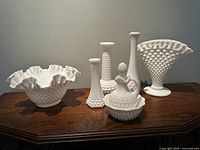 Full view of all 7 vintage white hobnail glass items including 4 vases, 2 bowls, and Avon perfume decanter.