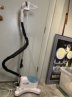 Full view of Tobi garment steamer standing upright with telescoping pole and steam nozzle.