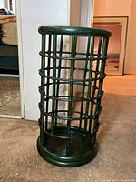 Full view of the vintage bamboo umbrella stand painted green, showing lattice construction and rounded top and bottom edges.
