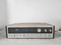 Front panel view showing tuning dial, volume and control knobs, indicator lights