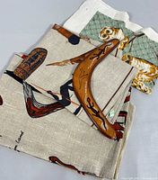 View showing the hand painted boomerang lying on top of two pieces of cloth with Australian animal prints including owls and birds.