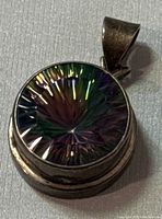 Clear top view of round mystic quartz stone with multi-color iridescence set in sterling silver bezel pendant