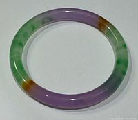 Clear top-down view of the round jade bangle showing its multicolor pattern and smooth polished surface.