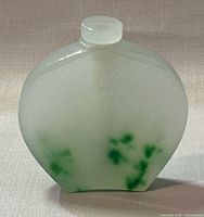 Front view of the jade bottle showing translucent white body with green inclusions.