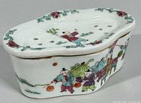 Oblique top view of lid showing pierced ventilation holes and painted child figure