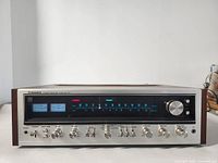 Front view of receiver showing tuning dial, VU meters, control knobs and wood side panels