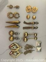 Full lot of 12 pairs vintage clip-on earrings laid out on white background showing various styles and finishes including gold-tone spheres, spikes, chains, and silver squares.