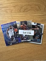 Lot containing three visible basketball cards: Kyrie Irving Express Lane, Joel Embiid Panini Mosaic, and a San Antonio Spurs player card.