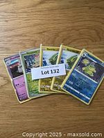 A photo of 5 Pokémon cards including Houndstone, Shroomish, Electrike, and a Japanese card