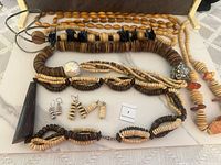 Three vintage natural material necklaces with matching earrings laid out in open box.