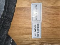Photo of a label on the wooden part of a piece of furniture showing 'Made in Vietnam' and the model number DIN-BC-010-024 BC-128AB-SUN.