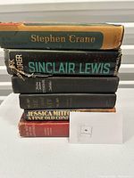 Stack of six vintage hardcover books with varying dust jacket conditions and visible shelf wear.