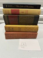Stack of five vintage hardcover books showing spines of titles and wear consistent with age