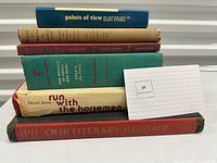 Side view of the stacked books showing thickness and titles on spines.
