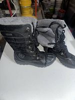 Pair of black Timberland waterproof boots size 7.5 shown side by side, one with the insulated lining folded open to show the interior.