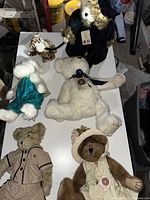 Full view of all six plush bears on table showing variety and outfits
