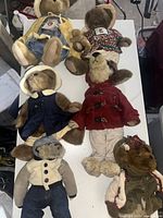Overview of six Boyd's Bears plush teddy bears arranged on table, showing various outfits and tag on one bear