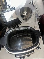 Ninja slow cooker, KitchenAid mixer, and waffle maker on a white table, showing overall set