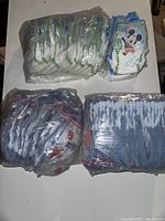 Packaging and loose premium training pants featuring Mickey Mouse and Superman themes in new condition.