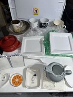 Overview of all ceramic items including mugs, plates, teapot, salt/pepper shakers, small pots, and holders.