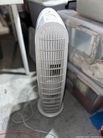 Full front view of the tall, slim Honeywell tower fan showing its vented grille and base standing on floor.