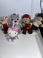 Front view of 6 plush toys including 4 collectible Starbucks bears, Hello Kitty, and TY Beanie Baby wolf plush