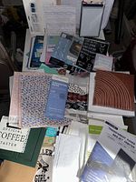 Photo showing assorted arts and crafts papers, decorative stickers, notes, and canvases arranged on a surface.