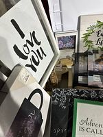 Photo showing framed canvas print with black 'I love you' text and various wooden decor boxes and plaques