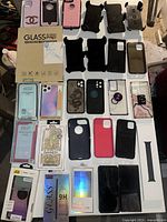 Top view of smartphones, cases, and screen protectors laid out on surface