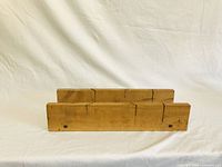 Front view of wooden miter box showing multiple saw slots