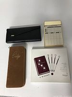 Brown Bridge case, black leather case with bridge accessories, bridge score pad, and graphic pencil box.