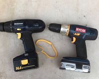 Mastercraft 14.4V cordless drill and Ryobi 18V drill side by side, showing both drills and batteries.