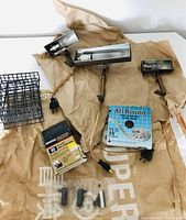 Overview of the lot showing the three vintage frame lights, fishing baits, sanding belt box, steel strap, and mounting hinge components.