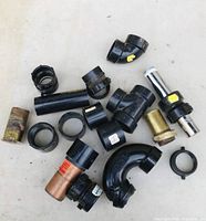 Overview of 16 assorted pipe ends and fittings arranged on a white surface.