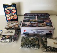 Full view of the puzzle bags and board games box including the Five Family Games and the tin box for the puzzle set.