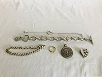 Photo showing the overall assortment of five jewelry pieces including bracelets, pendants and a gold ring