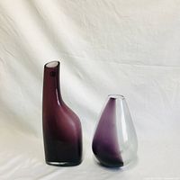 Two merlot gradient glass vases on white background, tall vase on the left with chip on rim, shorter rounded vase on the right.