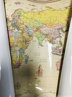 Photo of laminated world map section showing Europe, Asia, Africa, and Indian Ocean with cartographic detail and laminated glossy surface.