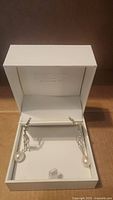 Pair of sterling silver chain-link dangle earrings with white hanging pearl in Effy branded white box.