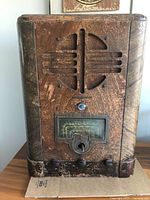 Front view of the wooden tombstone radio showing speaker grille, control knob and tuning dial.
