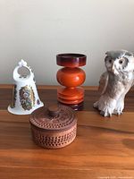 Lot displayed with owl figurine, bell, candleholder, and trinket box on wooden surface