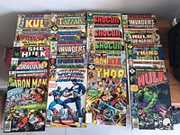 Top view of 30 vintage Marvel comic books laid out showing variety of titles and colorful covers