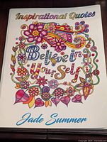 Front cover of adult colouring book titled 'Inspirational Quotes Believe in Yourself' by Jade Summer, with colorful floral design.